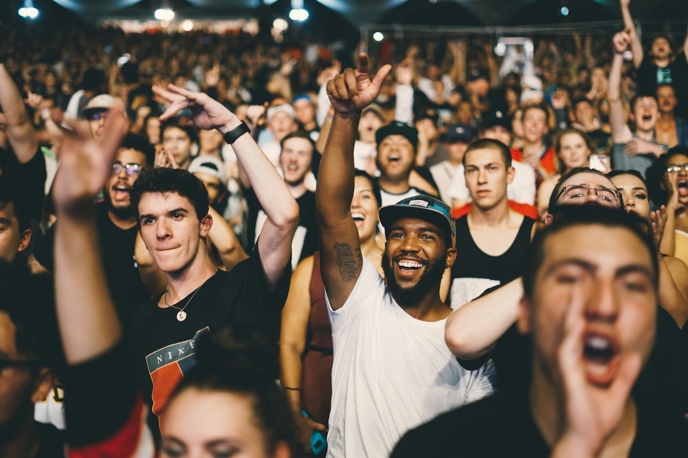 Outdoor music festival crowd facing a brightly lit stage