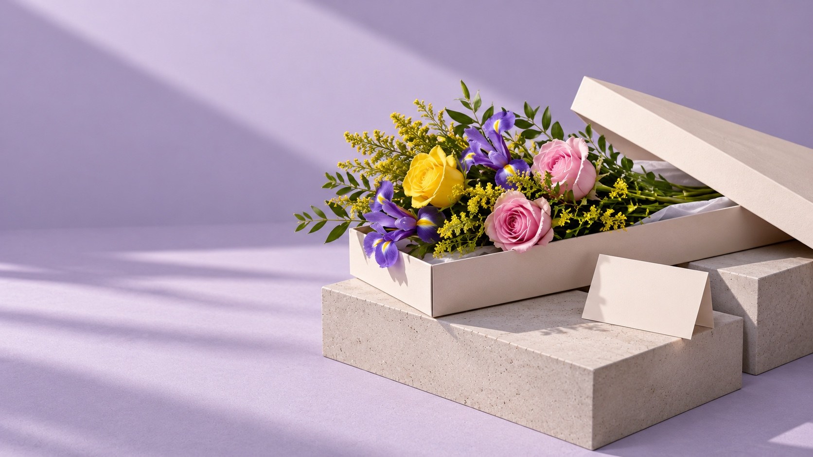 Yellow and pink roses, purple irises and solidago in an open letterbox flower box on pale concrete blocks against a lilac background