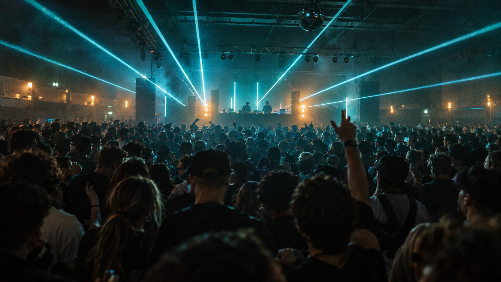 Illustrative indoor drum and bass crowd under blue and amber lights; generated from a real festival photograph